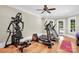 Well-equipped home gym with exercise machines, hardwood floors, and natural light for a healthy lifestyle at 1430 Rosehill Dr, Waxhaw, NC 28173