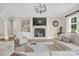 Elegant living room featuring a stone fireplace, built-in shelving, and stylish chandelier at 1430 Rosehill Dr, Waxhaw, NC 28173