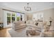 Bright and airy living room boasts large windows, hardwood floors, and modern light fixture at 1430 Rosehill Dr, Waxhaw, NC 28173