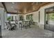 Covered outdoor patio with brick, dark trim, ceiling fan, and comfortable seating at 1430 Rosehill Dr, Waxhaw, NC 28173
