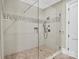 Modern walk-in shower featuring stylish tile accents, glass door, and multiple shower heads at 1430 Rosehill Dr, Waxhaw, NC 28173