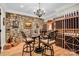 Elegant wine cellar featuring stone walls, a chandelier, custom wine racks, and a tasting table at 1430 Rosehill Dr, Waxhaw, NC 28173