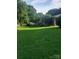 Expansive backyard with lush green grass, mature trees, and a home in the background at 1628 Cecelia Dr, Gastonia, NC 28054