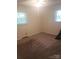 Neutral bedroom featuring tan carpet, two windows with blinds, and light-colored walls at 1628 Cecelia Dr, Gastonia, NC 28054