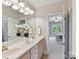 Inviting bathroom featuring double sinks, white cabinetry, tile flooring and views of the bedroom at 18618 Rollingdale Ln, Davidson, NC 28036