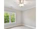 Bright bedroom featuring a ceiling fan, neutral walls, and a window with tree views at 18618 Rollingdale Ln, Davidson, NC 28036