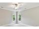 Sun-soaked bedroom features two windows, a ceiling fan and neutral-toned walls and carpeting at 18618 Rollingdale Ln, Davidson, NC 28036