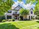 Stately brick home featuring a manicured lawn, covered entryway, and second story balcony at 18618 Rollingdale Ln, Davidson, NC 28036