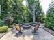 Charming backyard fire pit area with seating, set in a brick-paved patio and lush landscaping for cozy outdoor gatherings at 18618 Rollingdale Ln, Davidson, NC 28036