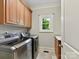 Laundry room with front load washer and dryer, storage cabinets, and utility sink at 18618 Rollingdale Ln, Davidson, NC 28036