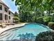Inviting backyard swimming pool with stone accents, surrounded by lush landscaping offering a private retreat at 18618 Rollingdale Ln, Davidson, NC 28036