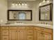 Bathroom featuring dual sinks, wooden cabinets, granite countertops, and framed mirrors at 213 Cowboys Cir, Rock Hill, SC 29732