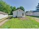View of the backyard with a white house, grassy lawn, and a separate driveway at 2414 Lane St, Kannapolis, NC 28083