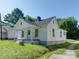 Quaint white home featuring black roof, chimney, and a cozy covered front porch area at 2414 Lane St, Kannapolis, NC 28083