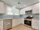 Bright kitchen featuring white cabinets, stainless appliances, and a stylish backsplash at 2414 Lane St, Kannapolis, NC 28083
