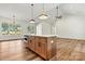 Spacious kitchen island with stone countertops, stainless appliances, and hardwood floors at 252 Teeter Rd, Mooresville, NC 28115