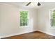 Sunlit bedroom with hardwood floors and two windows showing views of the lush surroundings at 308 Davis Park Rd, Gastonia, NC 28052
