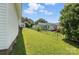 Expansive backyard with lush green grass, mature trees, and a chain-link fence at 310 Sidney Johnson St, Fort Mill, SC 29715
