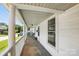 Inviting covered front porch with white pillars, ceiling fan, and ample seating area for relaxing at 310 Sidney Johnson St, Fort Mill, SC 29715
