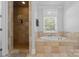 Bathroom featuring a stone shower, a large soaking tub, and natural light at 313 Sunset View Ct, York, SC 29745
