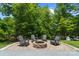 Backyard fire pit with chairs and gravel surrounded by green grass and trees at 313 Sunset View Ct, York, SC 29745