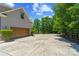 Side of the house featuring a garage with a wooden garage door and a long driveway at 313 Sunset View Ct, York, SC 29745