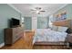Bright main bedroom featuring hardwood floors, ceiling fan, and a large bed with luxury bedding at 313 Sunset View Ct, York, SC 29745