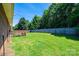 Large backyard with a wooden deck, a well-maintained lawn, and mature trees lining the property at 4128 River Run Cir, Hickory, NC 28602