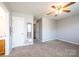 A carpeted bedroom with ceiling fan, doorway to bathroom and closet at 4128 River Run Cir, Hickory, NC 28602