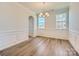 Elegant dining room with classic wainscoting, hardwood floors, and a stylish chandelier at 4178 Skyboat Cir, Fort Mill, SC 29715
