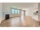 Bright living room featuring hardwood floors, a fireplace, and large windows for ample natural light at 4178 Skyboat Cir, Fort Mill, SC 29715
