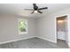 Bright bedroom with wood-look floors, ceiling fan, window view, and a door leading to a bathroom at 426 Williamson St, Rock Hill, SC 29730