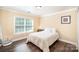 Cozy bedroom featuring a bright window, hardwood floors, and neutral wall colors at 4732 Meadowfield Rd # L35, Charlotte, NC 28215