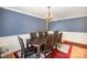 Formal dining room with chair rail molding, stylish chandelier and hardwood floors at 4732 Meadowfield Rd # L35, Charlotte, NC 28215