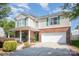 Inviting two-story home showcasing a front porch, green shutters, brick detailing, and a two-car garage at 4732 Meadowfield Rd # L35, Charlotte, NC 28215