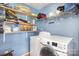 Well-lit laundry room includes a modern washer and dryer and ample shelving for storage at 4732 Meadowfield Rd # L35, Charlotte, NC 28215