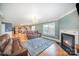 Open living room with a fireplace, leather sofa, and view into the kitchen at 4732 Meadowfield Rd # L35, Charlotte, NC 28215