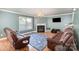Cozy living room featuring plush leather seating, a fireplace, and a large window for natural light at 4732 Meadowfield Rd # L35, Charlotte, NC 28215