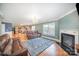 Open living room with a fireplace, leather sofa, and view into the kitchen at 4732 Meadowfield Rd # L35, Charlotte, NC 28215