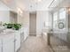 Bright bathroom with a double vanity, soaking tub, glass-enclosed shower, and tiled floor at 500 Landau Rd, Waxhaw, NC 28173
