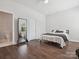 Bright bedroom with neutral walls, hardwood floors, large mirror, and ensuite bath access at 500 Landau Rd, Waxhaw, NC 28173