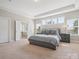 Relaxing bedroom showing a plush bed, bedside tables, and natural light from surrounding windows at 500 Landau Rd, Waxhaw, NC 28173