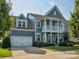Charming two-story home featuring a covered front porch, attached garage, and manicured lawn at 500 Landau Rd, Waxhaw, NC 28173