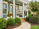 Inviting front porch features elegant columns, comfortable seating, and lush landscaping at 500 Landau Rd, Waxhaw, NC 28173