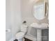 Clean powder room featuring a pedestal sink, toilet, and decorative mirror at 500 Landau Rd, Waxhaw, NC 28173