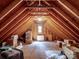 Unfinished attic space with exposed wooden beams and a small window, offering ample storage potential at 5572 Yorke Nw St, Concord, NC 28027
