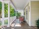 Relaxing front porch with classic columns, seating, and views of the lush, green neighborhood at 5572 Yorke Nw St, Concord, NC 28027