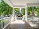 Charming porch view features classic white railings and columns, framing the picturesque street at 5572 Yorke Nw St, Concord, NC 28027