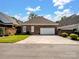 Brick detached garage with a wide driveway and manicured landscaping at 5572 Yorke Nw St, Concord, NC 28027