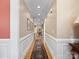 Spacious hallway boasts hardwood floors, neutral paint, and elegant wainscoting detail throughout at 5572 Yorke Nw St, Concord, NC 28027